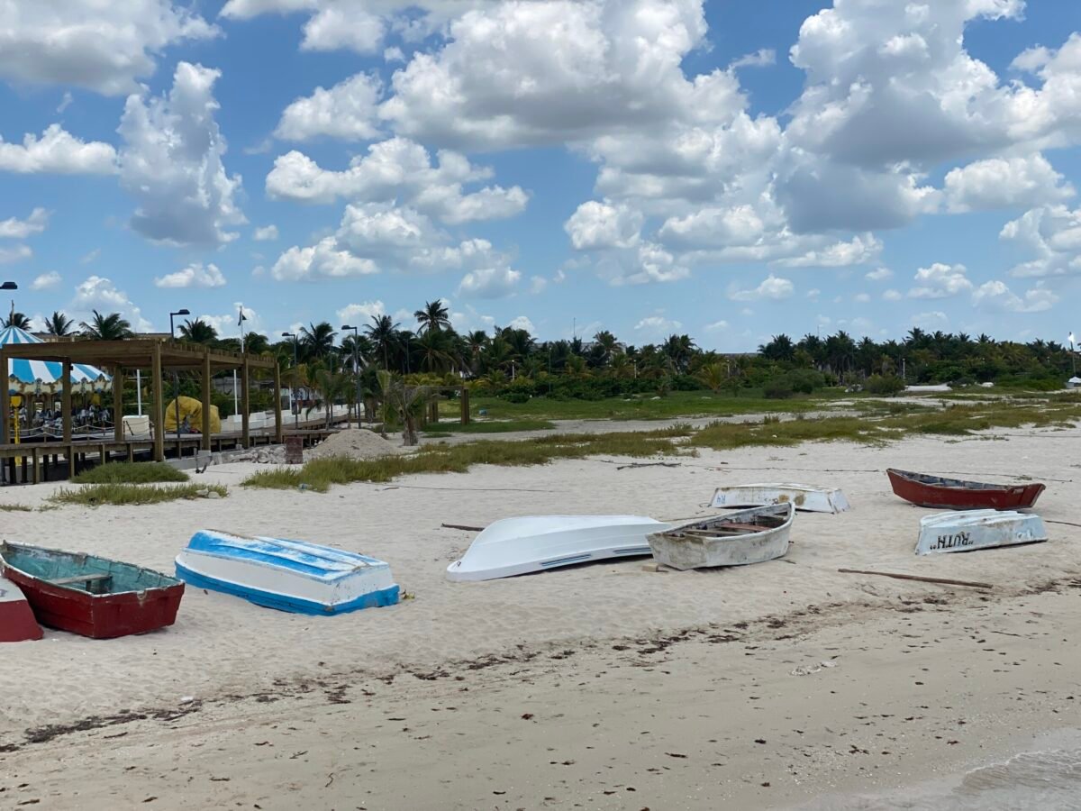 Colorful fishing boats resting on a white sand beach near Mérida, Yucatán, Mexico