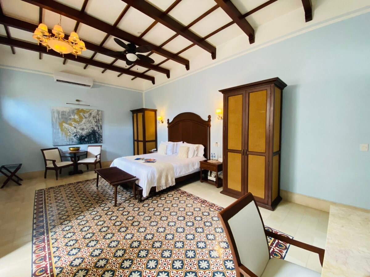 pacious bedroom in a Mérida long term rental featuring traditional pasta tile floors and an exposed wood beam ceiling