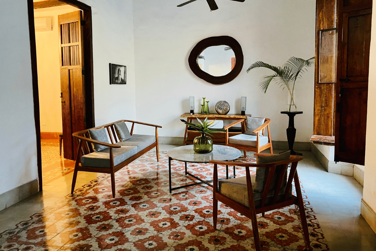 Living room in a Mérida rental home with original pasta tile floors and mid-century modern wood furniture