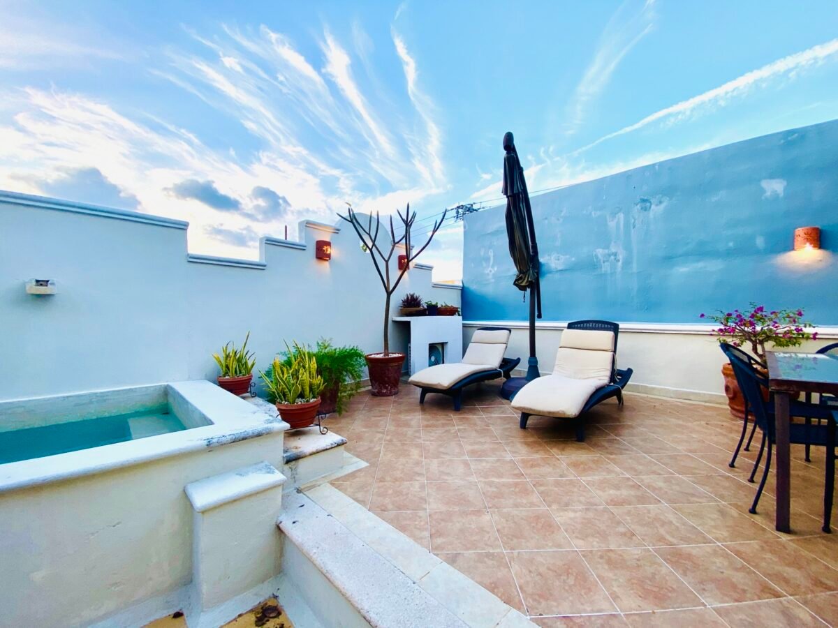 Blue skies overlooking a patio with loungers and pool in Merida Yucatan