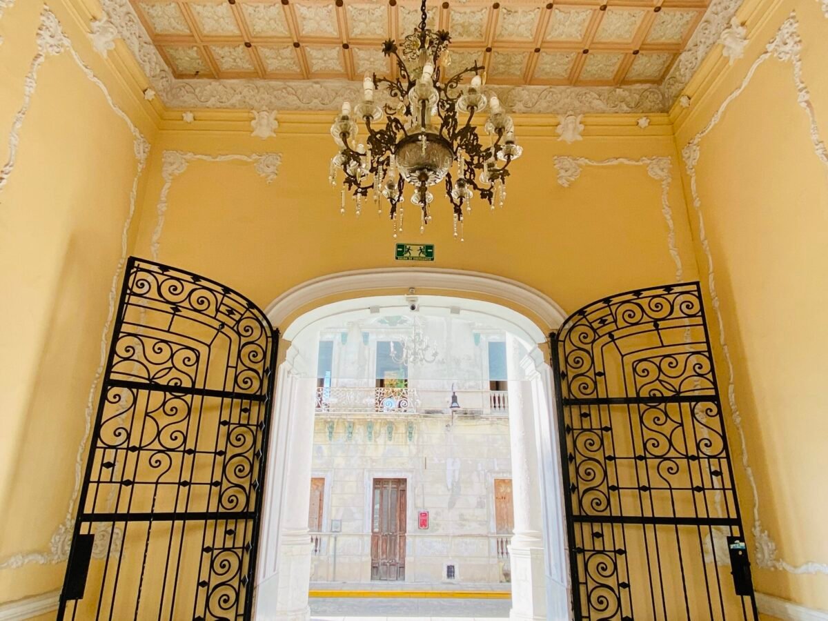 Yellow foyer with antique crystal chandelier in a colonial hotel in centro in Merida Mexico