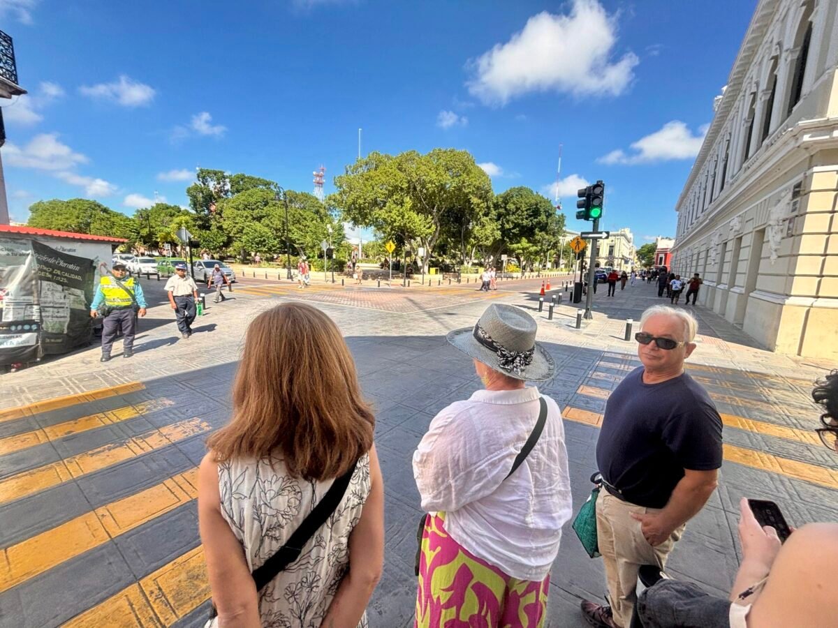 Blue sky background over a Centro street in Merida Yucatan with people getting ready to cross