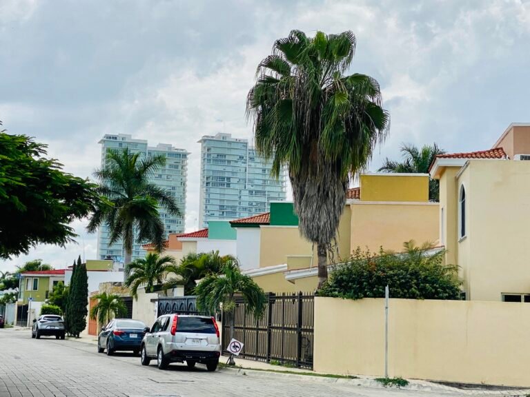 Residential street in the North Mérida neighborhood of Altabrisa showing modern condos, gated homes, and palm trees in Yucatán, Mexico