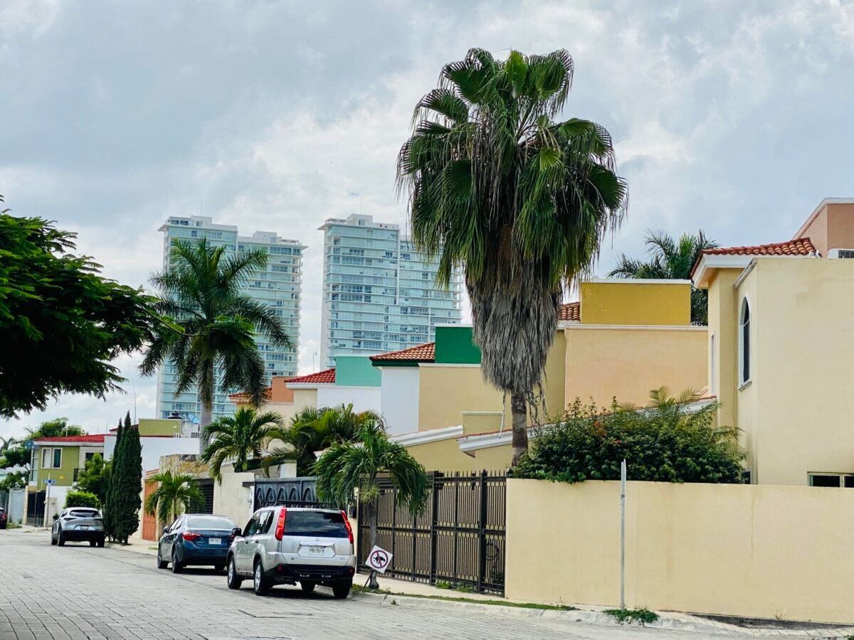 Residential street in the North Mérida neighborhood of Altabrisa showing modern condos, gated homes, and palm trees in Yucatán, Mexico